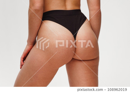 A woman with a beautiful feminine figure in black lingerie with overweight, cellulite and stretch marks. A woman with a beautiful feminine figure in black lingerie with overweight, cellulite and stretch marks. 108962019