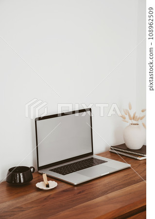 Laptop with blank screen on wooden table in home interior. Workplace mockup concept 108962509