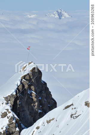 Snow covered high mountains, fog and clouds raising from above 108963268