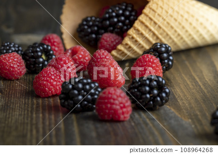 Ripe red raspberries in a crispy waffle cone 108964268
