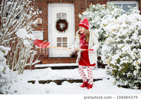 Child shoveling winter snow. Kids clear driveway. 108964379