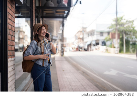 Happy young Asian tourist woman using smartphone on street with market background, Female traveller in Chiang mai enjoy shopping market during holidays 108964398