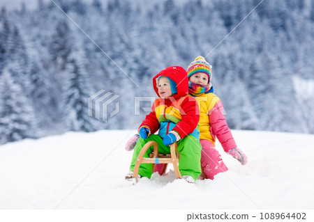 Kids play in snow. Winter sleigh ride for children Kids play in snow. Winter sleigh ride for children 108964402