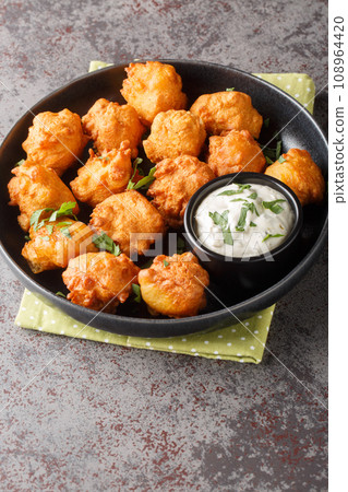 Hush puppies, southern food, deep fried cornbread balls closeup on the plate. Vertical 108964420