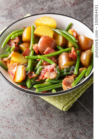 Jacket potatoes with bacon and green beans close-up in a bowl. Vertical 108964431