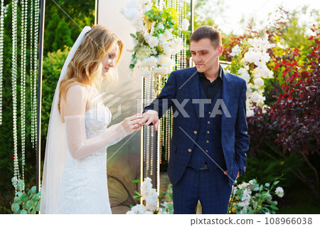 The bride and groom exchanging rings at the wedding ceremony venue  108966038