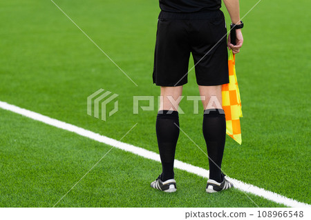 Assistant referee moving along the sideline during a soccer match. 108966548