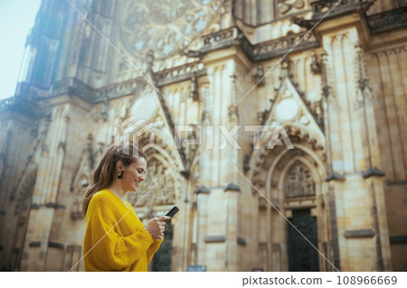 woman in Prague enjoying promenade, using phone and walking 108966669