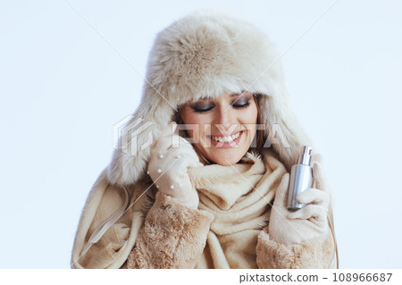 smiling stylish woman in winter coat and fur hat on white smiling stylish woman in winter coat and fur hat on white 108966687