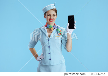 happy stewardess woman on blue showing smartphone blank screen 108966754