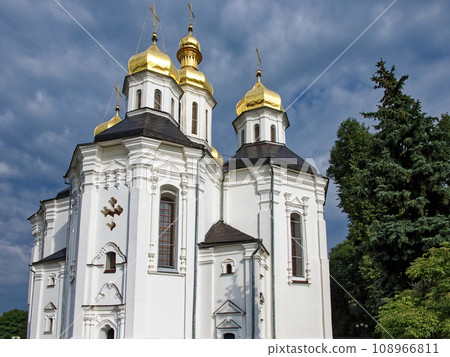 The Orthodox Church of St. Catherine in Chernihiv, Ukraine, emerges as a pristine white church adorned with gleaming golden domes and crosses, beautifully nestled amidst lush greenery. The Orthodox Church of St. Catherine in Chernihiv, Ukraine, emerges as a pristine white church adorned with gleaming golden domes and crosses, beautifully nestled amidst lush greenery. 108966811