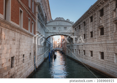 A peaceful and serene view of a narrow canal in Venice, Italy, with no specific landmarks visible. The canal is typically navigated by gondolas, creating a tranquil atmosphere. 108966915
