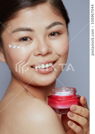Portrait of modern asian woman with facial cream jar Portrait of modern asian woman with facial cream jar 108967044