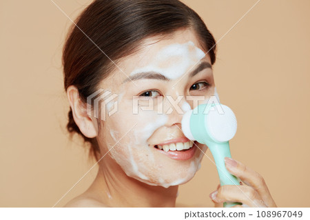 young asian female with massager washing face 108967049