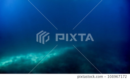 Abstract blurred underwater shot of sea bottom and sun rays shining through water surface. Abstract blurred underwater shot of sea bottom and sun rays shining through water surface. 108967172