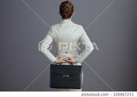 Seen from behind business owner woman in light business suit 108967251