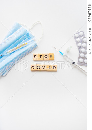 Stop coronavirus inscription. A new strain of coronavirus-omicron, pyrola. Preparing for vaccination against covid. Syringe, vaccine, pills, medical mask. 108967456
