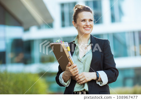 smiling modern woman worker in business district smiling modern woman worker in business district 108967477