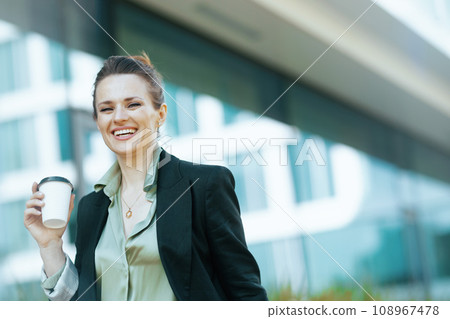 Portrait of smiling woman worker in business district walking 108967478