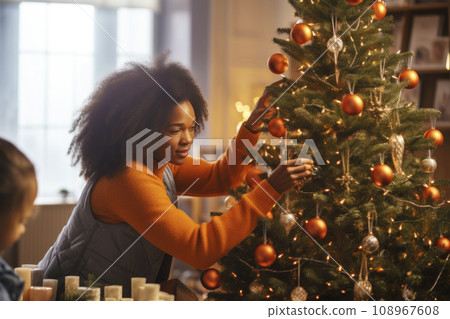 African American mom and daughter decorate a Christmas tree together African American mom and daughter decorate a Christmas tree together 108967608