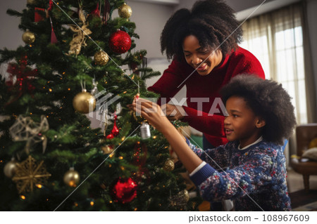 African American mom and daughter decorate a Christmas tree together 108967609