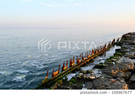 old wooden pier on the Baltic spit, Baltiysk, Kaliningrad region, beautiful sunset on the sea 108967677