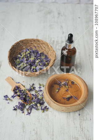 Essential lavender oil and flowers on table with copy space  108967707