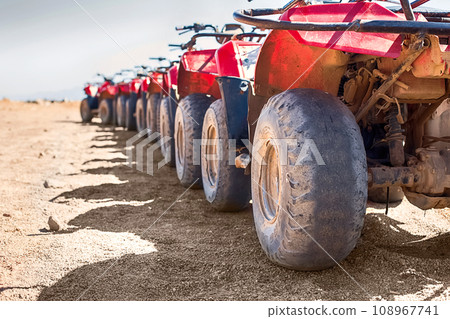 Red quads stand in a row on the shore of the Red Sea. Dahab, Egypt. Red quads stand in a row on the shore of the Red Sea. Dahab, Egypt. 108967741