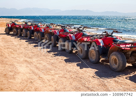 Red quads stand in a row on the shore of the Red Sea. Dahab, Egypt. 108967742