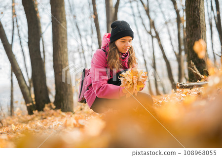 Young woman in a hat collects autumn leaves. Fall season concept. Generation Z and gen z youth 108968055