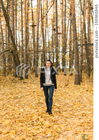 Outdoor atmospheric lifestyle portrait of young beautiful young woman copy space. Warm autumn fall season. Millennial generation and youth Outdoor atmospheric lifestyle portrait of young beautiful young woman copy space. Warm autumn fall season. Millennial generation and youth 108968848