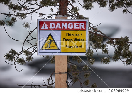 Thin ice warning sign post in winter 108969009