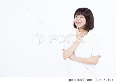 A female nurse in her thirties thinking with a smile 108969193