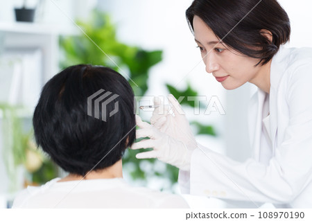 Cosmetic surgeon giving cosmetic injections 108970190