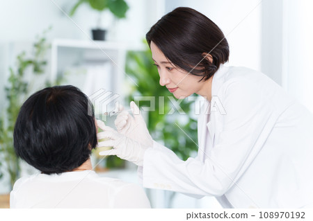 Cosmetic surgeon giving cosmetic injections 108970192