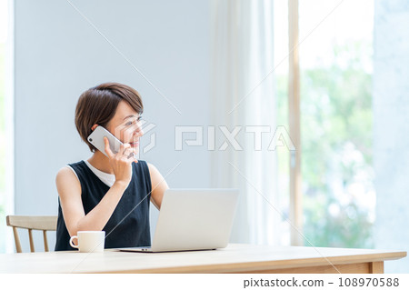 一位女士在客廳遠程辦公。 一位女士在客廳遠程辦公。 108970588