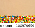 Collection of plastic caps on cardboard background. PET recycling plastic bottle cap recycling bottle cap PET plastic lids on recycling background. Recyclable materials. Sorting waste separation. 108970659
