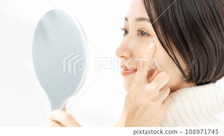 A woman looking at a hand mirror and worrying about Kuroko 108971745