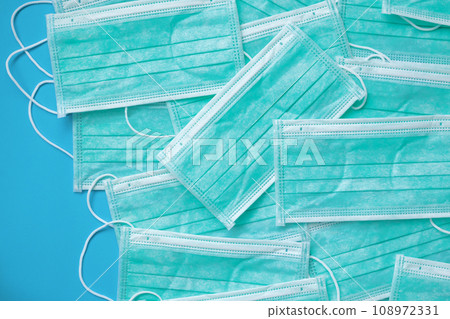 Surgical face mask on blue background protection against COVID-19 coronavirus. Healthcare and medical concept Surgical face mask on blue background protection against COVID-19 coronavirus. Healthcare and medical concept 108972331