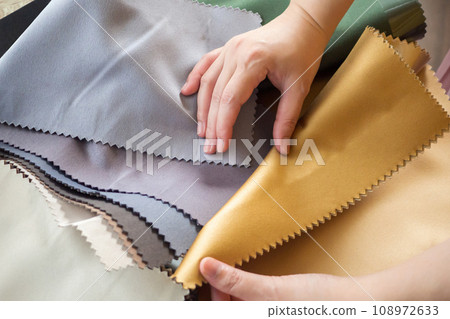 female designer with fabric color samples choosing textile for curtains 108972633