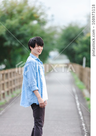 Refreshing young man walking on the sidewalk 108973118