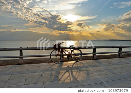 Bicycle and shadow placed on the beach at sunset 108973679