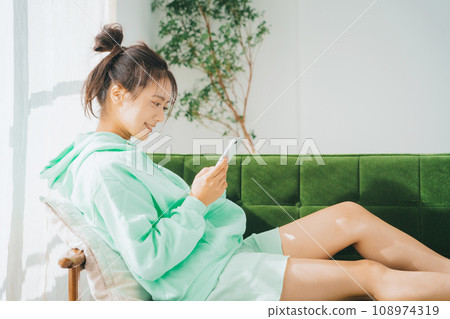 一位穿著家居服使用智慧型手機的女士 108974319