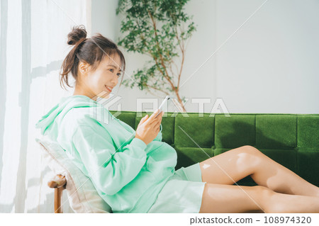 一位穿著家居服使用智慧型手機的女士 108974320