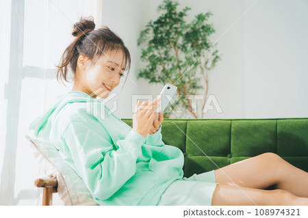一位穿著家居服使用智慧型手機的女士 108974321
