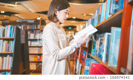 Portrait of young adult southeast asian woman reading book at bookstore shop Portrait of young adult southeast asian woman reading book at bookstore shop 108974541