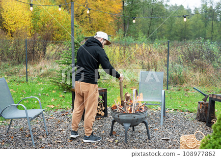 A man lights a barbecue in nature A man lights a barbecue in nature 108977862