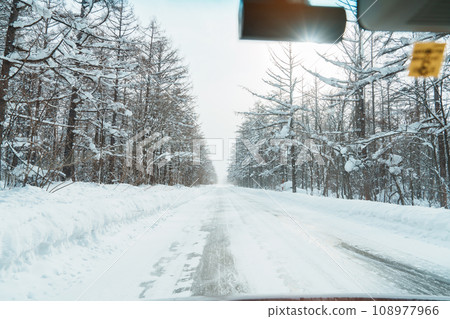 Beautiful snow road forest view during car driving in winter season. Winter travel, Road trip, Adventure, Exploring and Vacation concepts 108977966