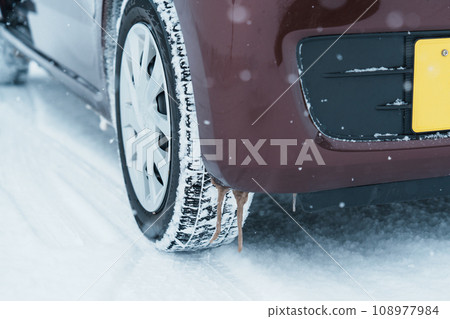 Car wheel tires on the road covered with snow in winter season, Vehicle on snowy way at snowfall 108977984