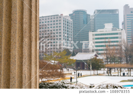 Snowy winter Deoksugung Palace and office buildings in Seoul, Korea 108978355